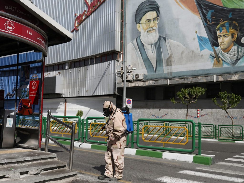 A volunteer from Basij forces sanitizes a bus station amid the coronavirus disease fears, in Tehran, Iran. Photo credit: WANA/Ali Khara via REUTERS.