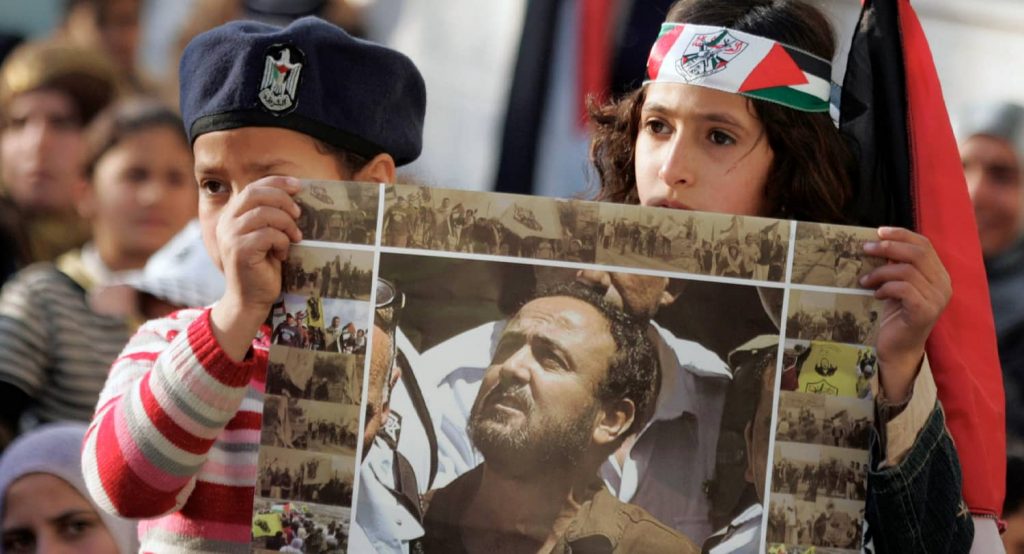 Palestinian children hold a poster depicting jailed Fatah leader Marwan Barghouti. Photo credit: REUTERS
