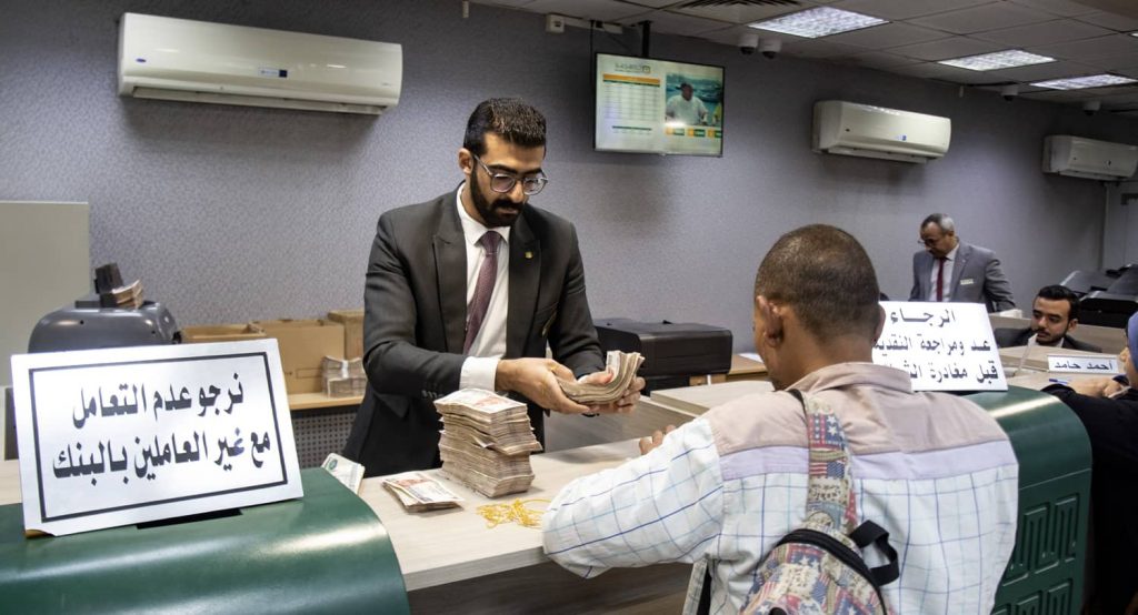 Egyptian Pound Free Falls Since IMF Loan. People turn to Banque Misr and the National Bank to buy three-year savings certificates, April 2023, Cairo, Egypt. Photo credit: Mahmoud Elkhwas via Reuters Connect