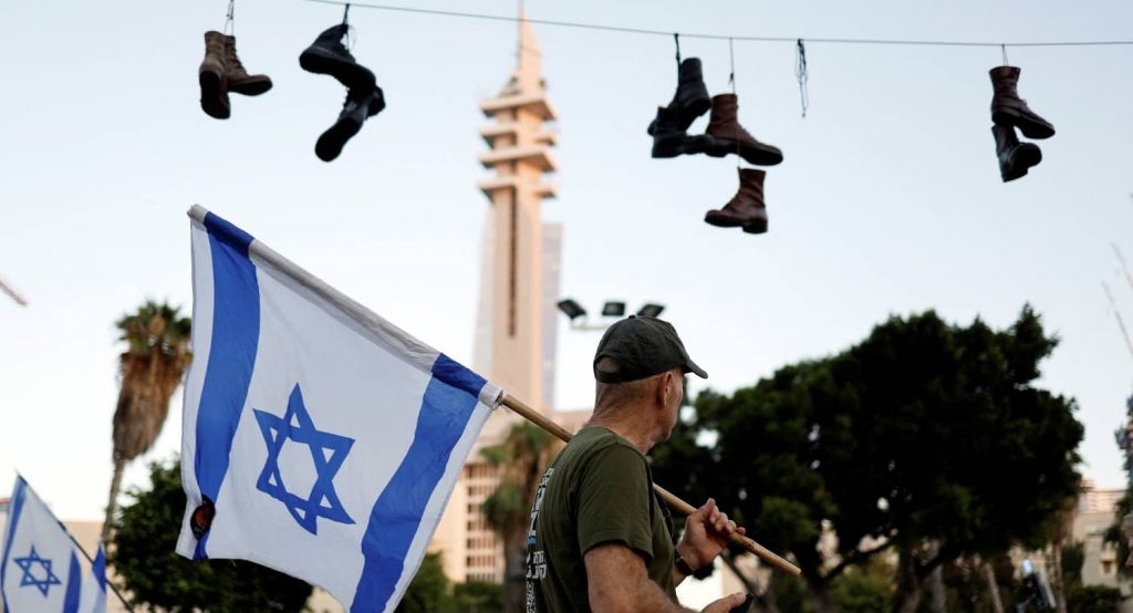 Army boots hang on a wire during a protest of reservists near the Ministry of Defense in Tel Aviv, July 2023. Photo credit: REUTERS/Amir Cohen