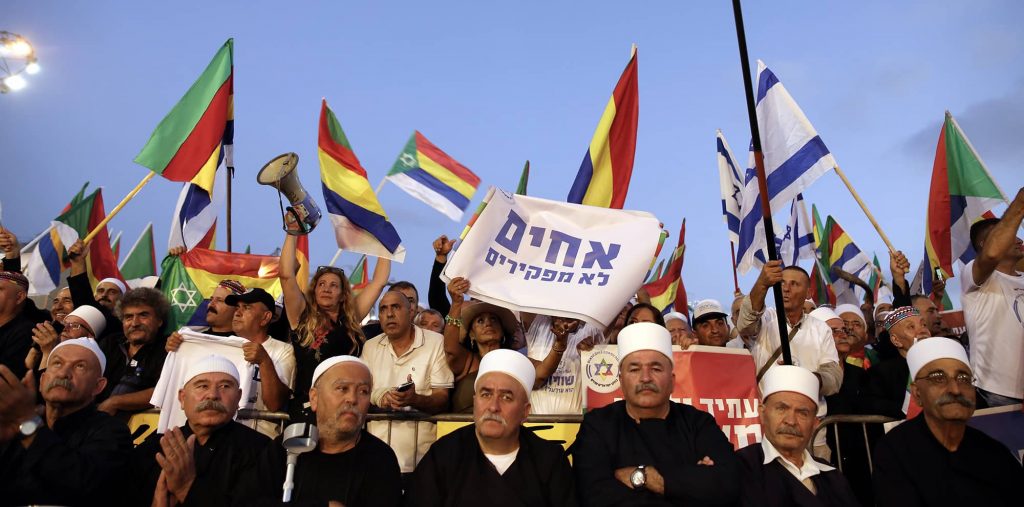 Leaders from the Druze community take part in a rally against "Nationality Law" in Tel Aviv, August 2018. The sign in Hebrew reads: "Brothers shall not to be abandoned". Photo credit: REUTERS/ Corinna Kern