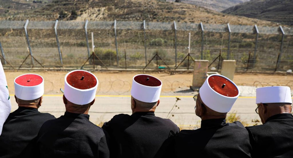Druze in the Golan town of Majdal Shams look out at the demilitarized zone separating Israel and Syria. Photo credit: REUTERS/Ammar Awad