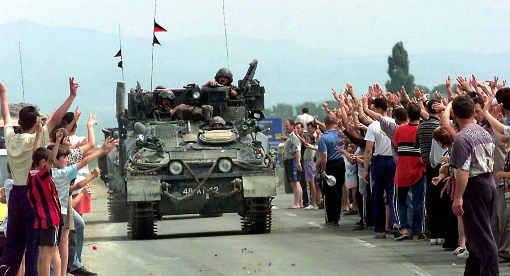 Kosovars greet members of the British Army as part of the NATO peacekeeping force, June 12, 1999. Photo credit: PA Images via Reuters Connect.